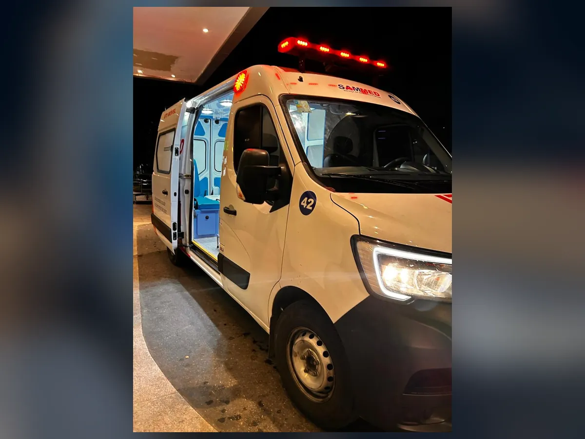 Ambulância SAMMED à noite, com iluminação ligada e porta lateral aberta
