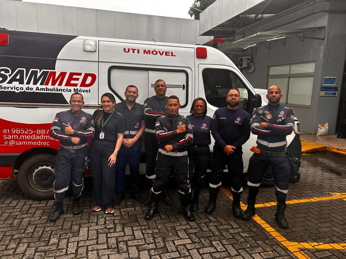 Profissionais da SAMMED reunidos ao lado de uma ambulância
